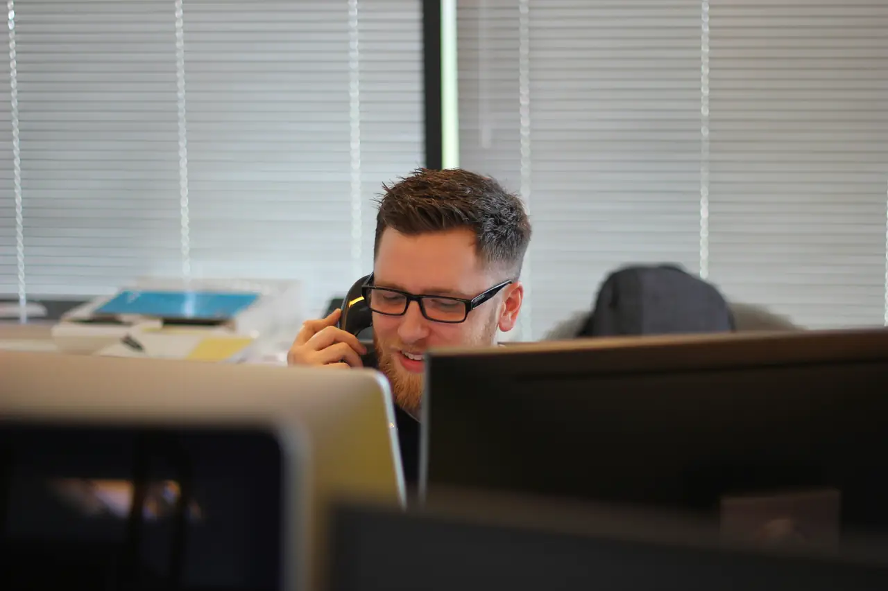 Operatore sorridente al telefono in ufficio