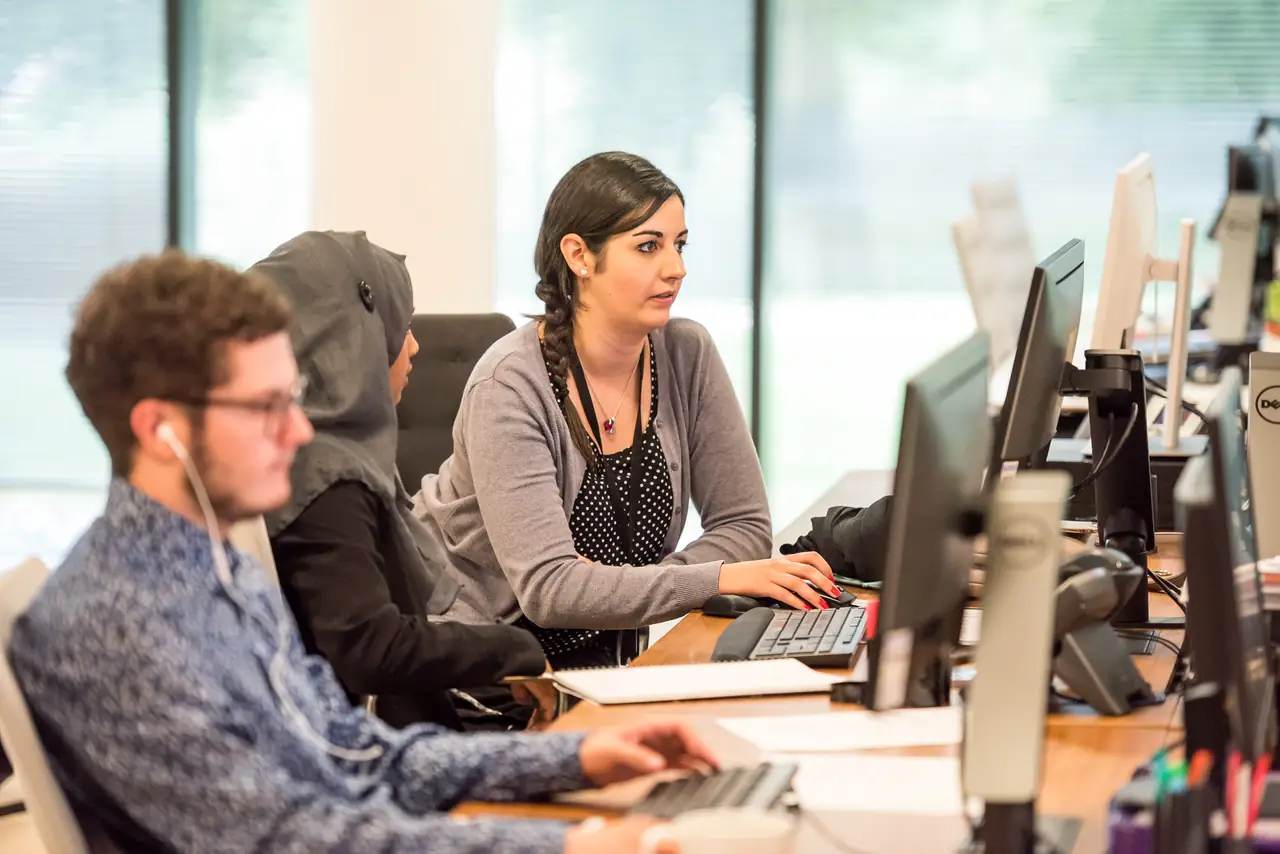 Persone al lavoro davanti ai computer in un ufficio luminoso